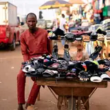 Trader selling sandals from a barrow at a market in Jos