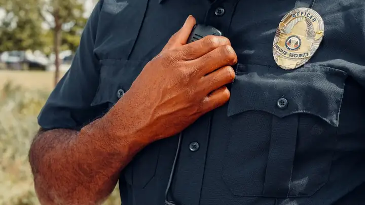 Security guard speaking into a shoulder radio