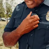 Security guard speaking into a shoulder radio